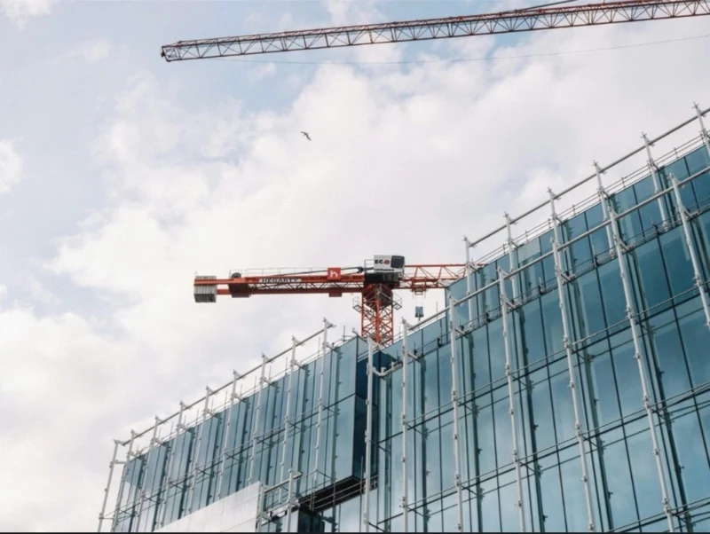 Tower crane at a modern glass building construction site