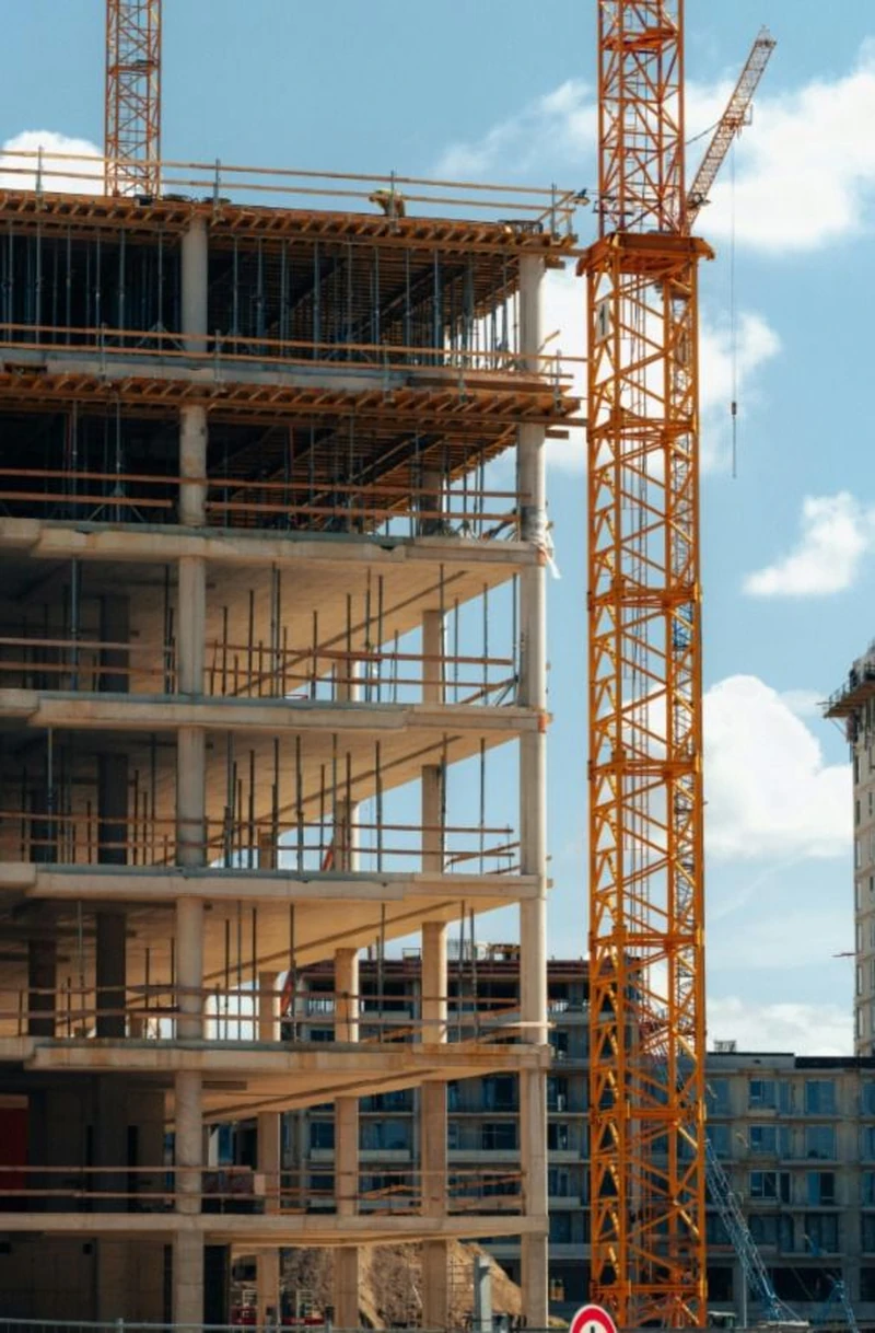 Concrete building frame under construction with tower crane